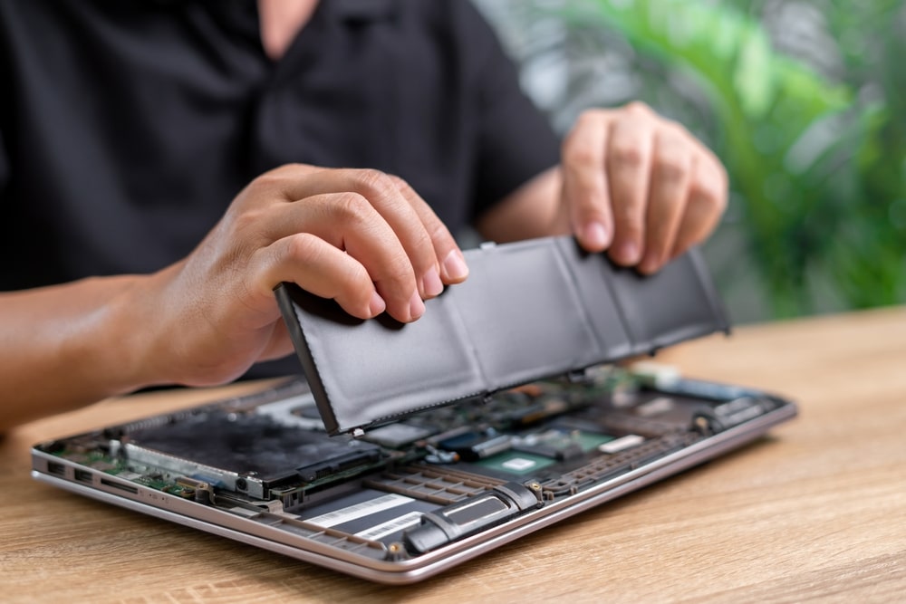 Technician testing the battery health of a refurbished laptop