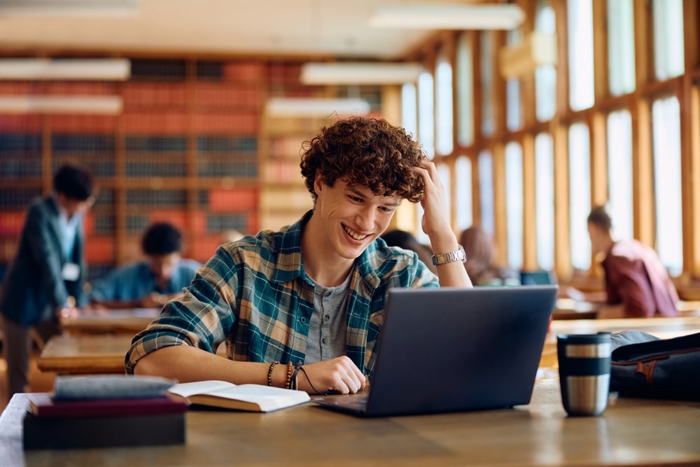 Student using a refurbished laptop in a school library setting.